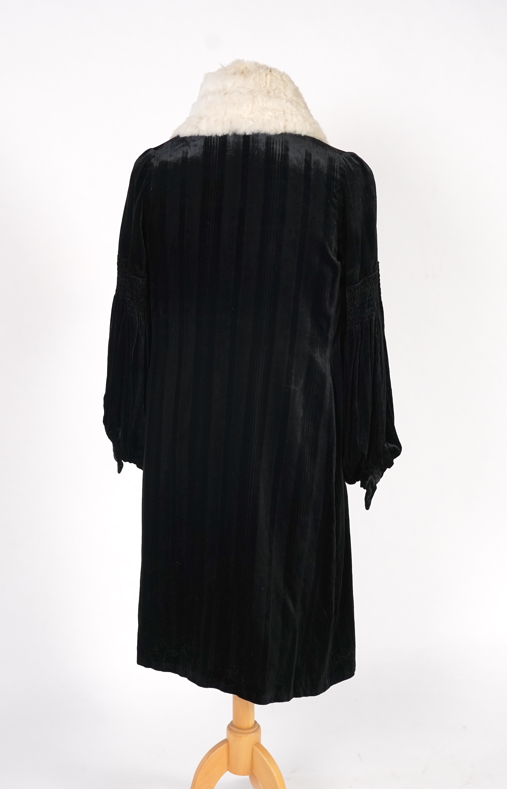 A 1920's ladies black striped silk velvet opera coat with a wide white fur collar and cream satin lining.